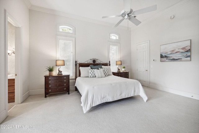 carpeted bedroom with ornamental molding, ensuite bathroom, and ceiling fan