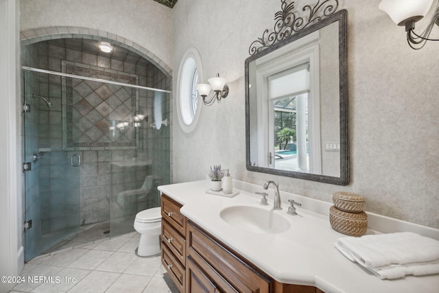 bathroom featuring a shower with door, vanity, toilet, and tile patterned flooring