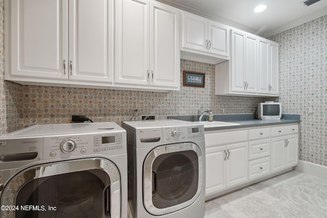 laundry area with ornamental molding, sink, light tile patterned floors, washing machine and clothes dryer, and cabinets