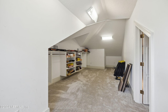 bonus room featuring a textured ceiling, vaulted ceiling, and light colored carpet