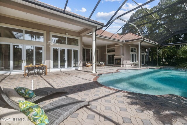 view of pool featuring a patio, glass enclosure, and ceiling fan