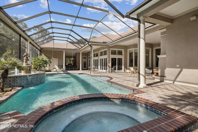 view of pool featuring an in ground hot tub, a patio area, and a lanai