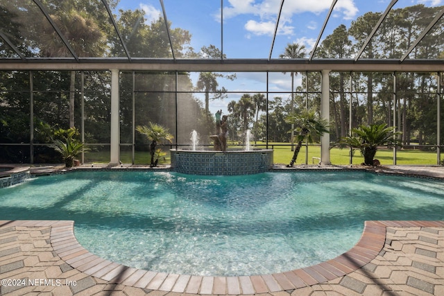 view of swimming pool with pool water feature, a lawn, and a lanai