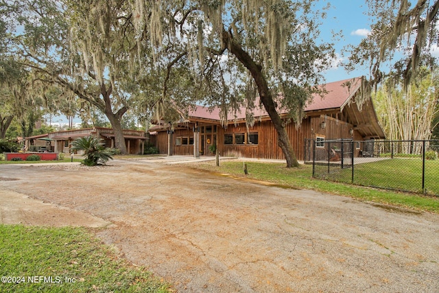 view of front of house with driveway, a front lawn, and fence