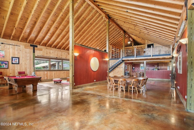 interior space with high vaulted ceiling, billiards, finished concrete flooring, and wooden walls