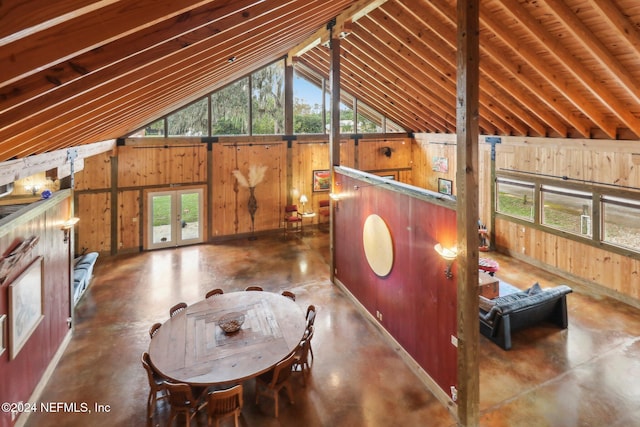 interior space with a healthy amount of sunlight, concrete floors, and wooden walls