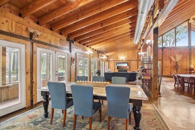 dining space featuring vaulted ceiling with beams, french doors, plenty of natural light, and wooden walls