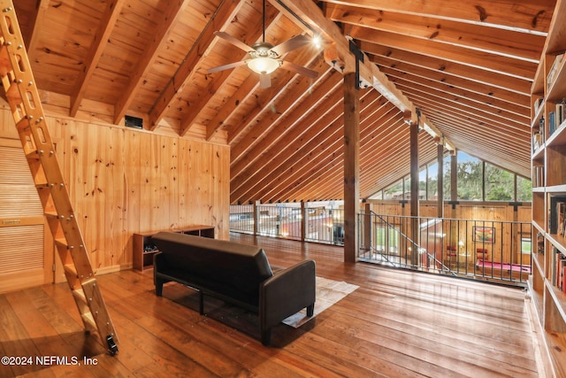 living room featuring vaulted ceiling with beams, ceiling fan, wooden ceiling, hardwood / wood-style flooring, and wood walls