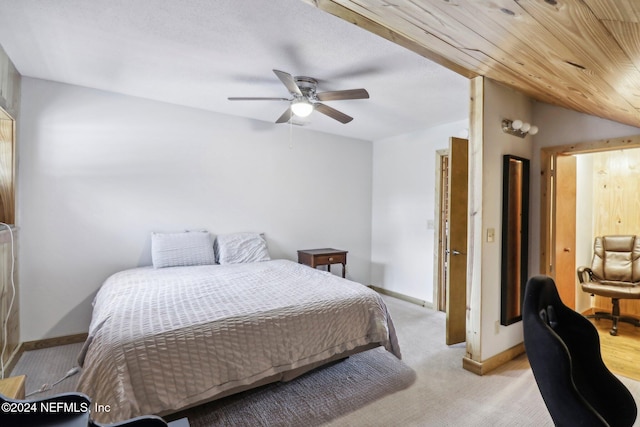 bedroom with light carpet, vaulted ceiling, baseboards, and ceiling fan