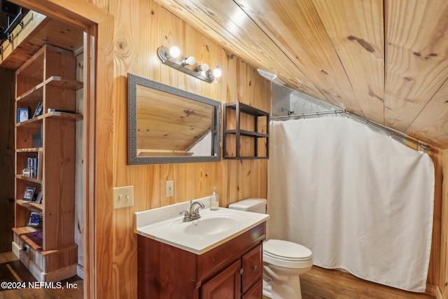 bathroom featuring toilet, wood ceiling, wooden walls, vanity, and wood finished floors