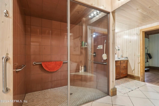 full bath featuring a stall shower, wooden walls, wooden ceiling, tile patterned flooring, and vanity