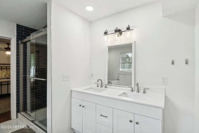 bathroom featuring a stall shower, a sink, and double vanity