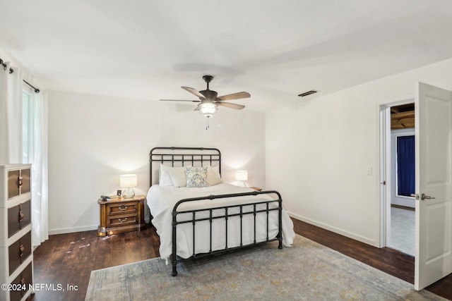 bedroom with a ceiling fan, wood finished floors, visible vents, and baseboards