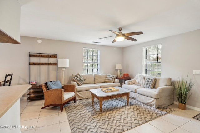 living room featuring a ceiling fan, visible vents, baseboards, and light tile patterned floors