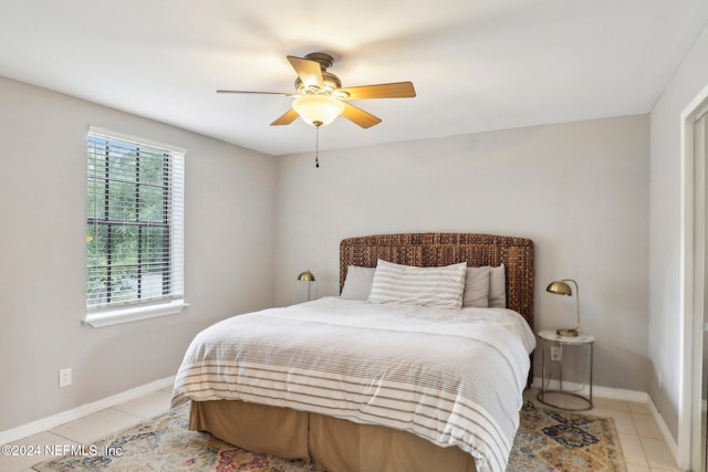 bedroom featuring light tile patterned flooring, a ceiling fan, and baseboards