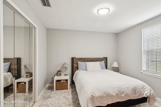 bedroom featuring baseboards, visible vents, and a closet