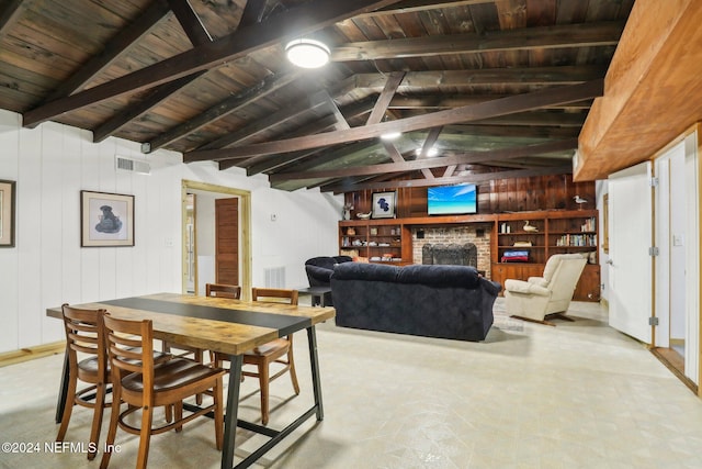 dining area with wood ceiling, visible vents, a fireplace, and wood walls