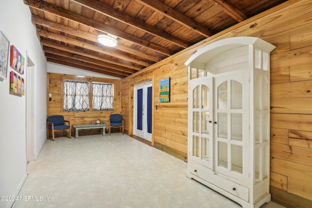 sitting room with wooden ceiling, wood walls, vaulted ceiling with beams, and tile patterned floors