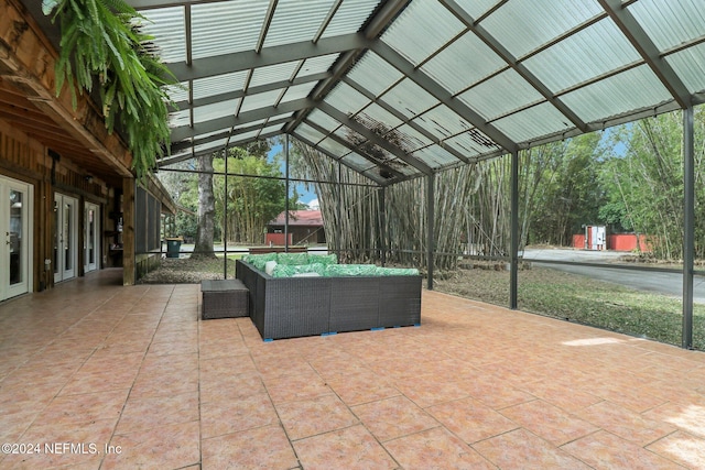 view of patio / terrace featuring french doors, glass enclosure, and an outdoor hangout area