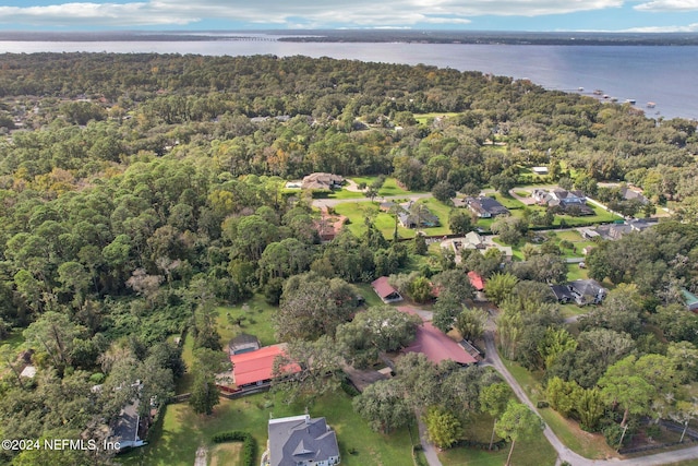 birds eye view of property with a water view and a wooded view