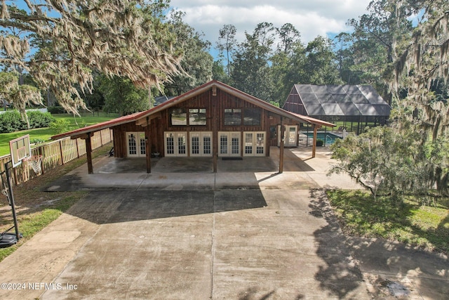 back of property with french doors and fence