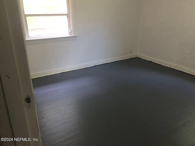 unfurnished room with dark hardwood / wood-style flooring