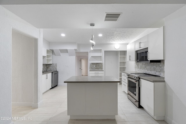 kitchen with appliances with stainless steel finishes, tasteful backsplash, white cabinets, and pendant lighting