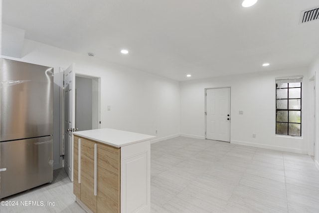 kitchen featuring stainless steel refrigerator and light brown cabinets