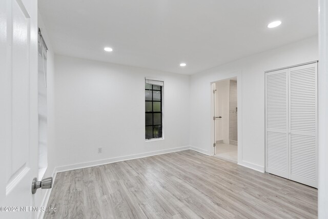 unfurnished bedroom featuring connected bathroom and light hardwood / wood-style floors