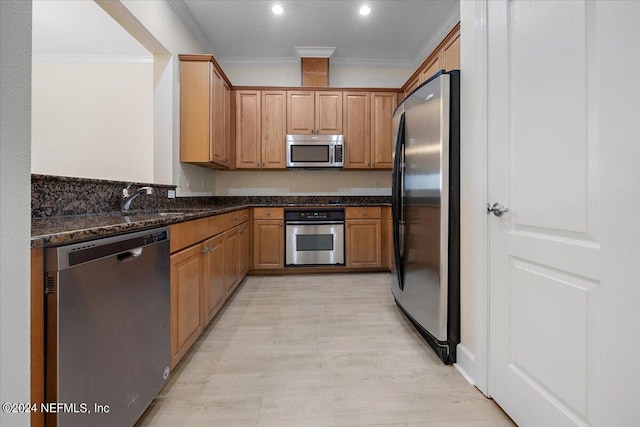 13846 Atlantic Blvd Unit 405, Jacksonville, FL 32225 - kitchen featuring light wood finished floors, dark stone counters, ornamental molding, appliances with stainless steel finishes, and a sink