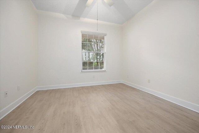 unfurnished room with ceiling fan, light hardwood / wood-style floors, and vaulted ceiling