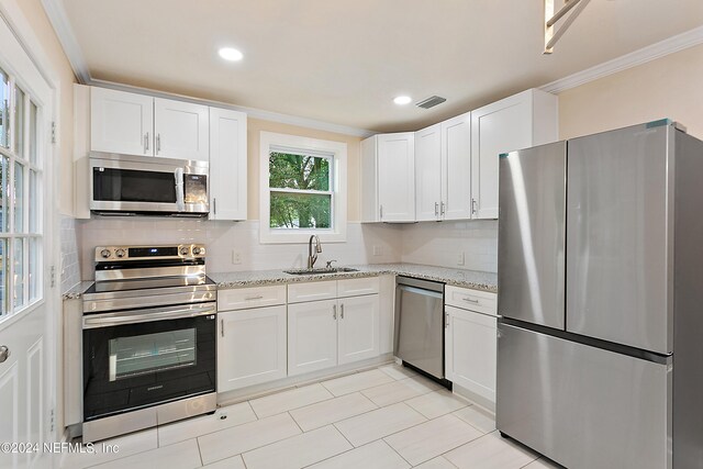 kitchen featuring appliances with stainless steel finishes, white cabinetry, and sink