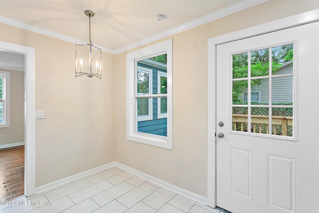 entryway with a notable chandelier and ornamental molding