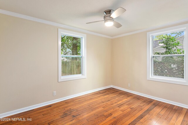 empty room featuring ceiling fan, hardwood / wood-style flooring, plenty of natural light, and ornamental molding