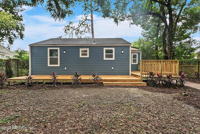 rear view of property featuring a wooden deck