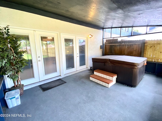 sunroom / solarium featuring a jacuzzi, plenty of natural light, and french doors