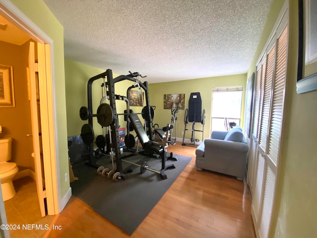 workout area with a textured ceiling and hardwood / wood-style floors