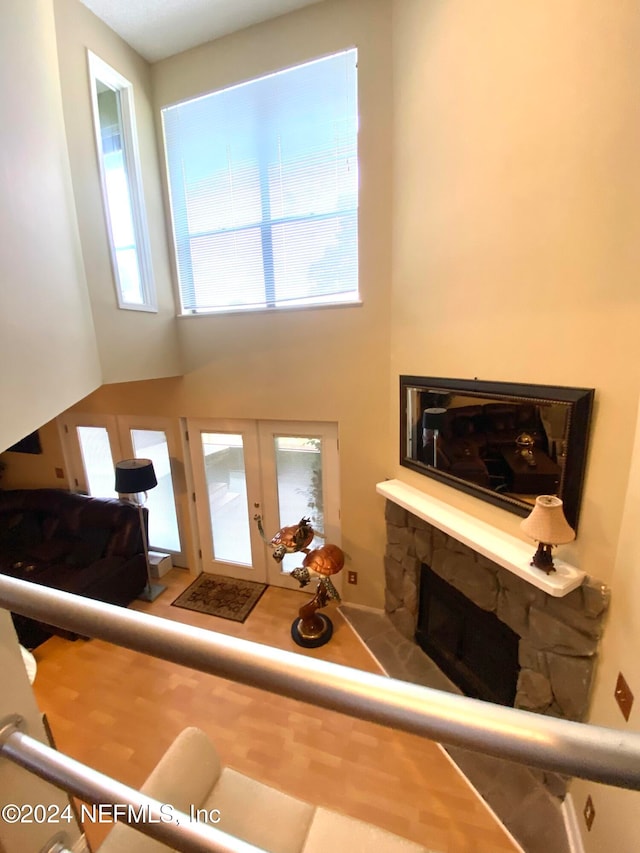 living room with french doors, a fireplace, a high ceiling, and a healthy amount of sunlight