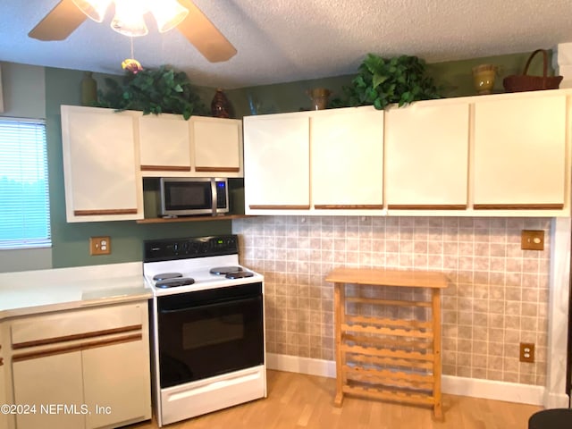 kitchen with electric stove, a textured ceiling, light hardwood / wood-style floors, and white cabinetry