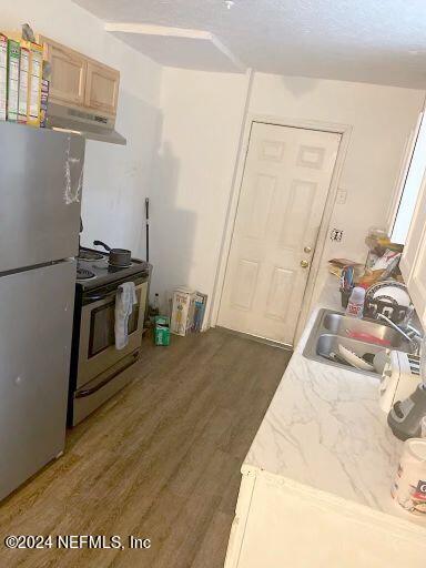 kitchen featuring electric stove, fridge, dark hardwood / wood-style flooring, light brown cabinetry, and exhaust hood