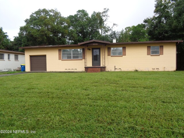 ranch-style home featuring a front lawn and a garage