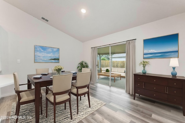 dining area with lofted ceiling and light hardwood / wood-style flooring