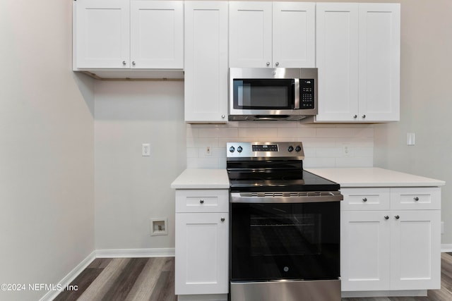 kitchen featuring dark hardwood / wood-style floors, decorative backsplash, white cabinetry, and stainless steel appliances