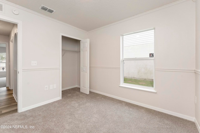 unfurnished bedroom featuring a closet, carpet, and multiple windows