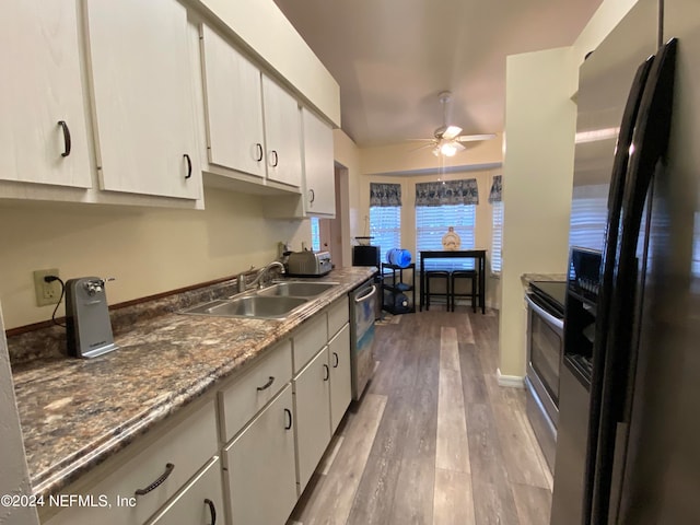 kitchen with appliances with stainless steel finishes, hardwood / wood-style flooring, white cabinetry, and ceiling fan