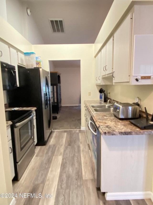 kitchen featuring light wood-type flooring, stainless steel appliances, white cabinetry, and sink