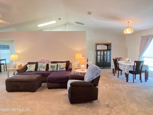 carpeted living room featuring lofted ceiling and an inviting chandelier