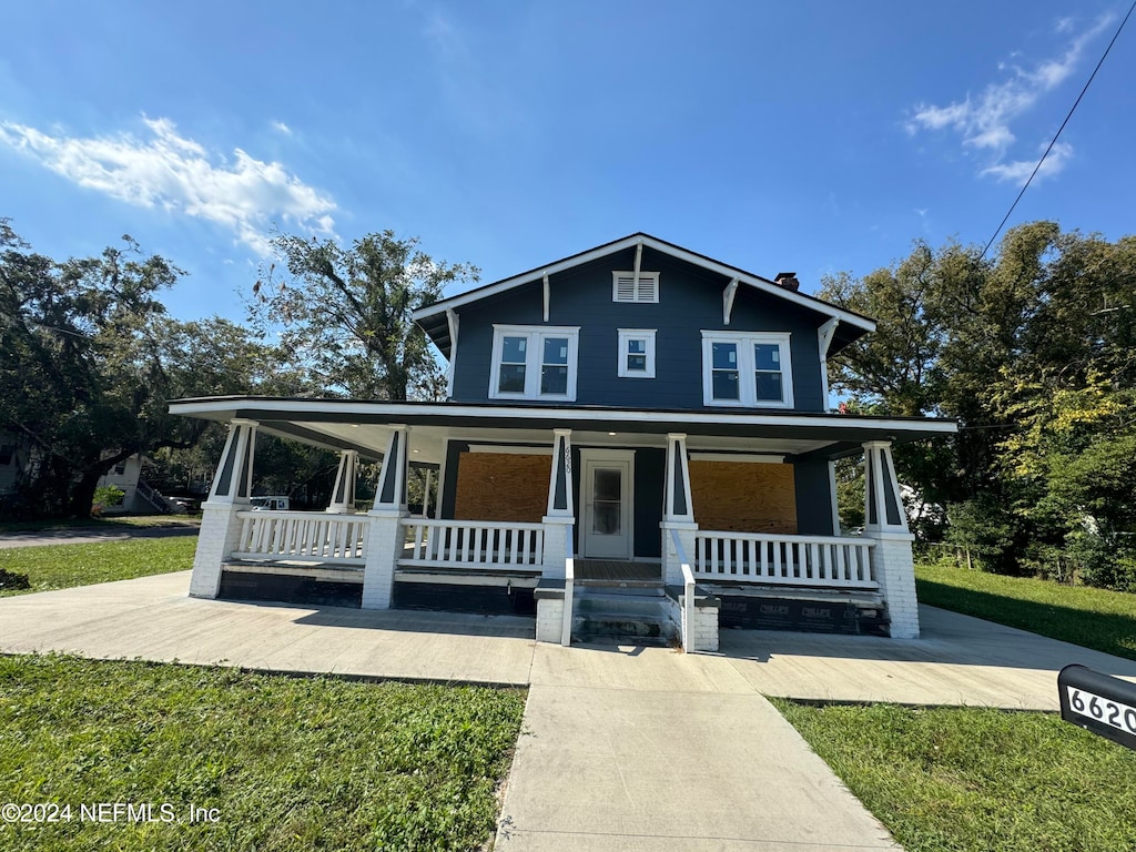 view of front of home with covered porch and a front yard