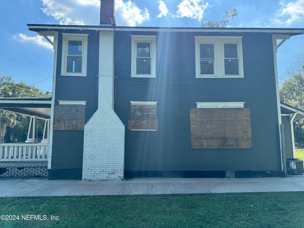 view of home's exterior with a porch, central AC unit, and a lawn