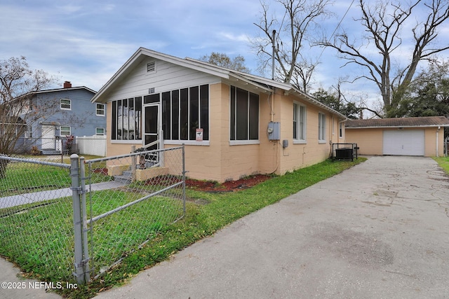 view of front of home featuring central AC, a front lawn, a garage, and a sunroom